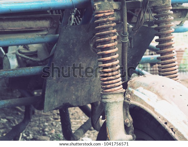 Shock absorber of old\
motorcycle,Rust and mud at shock absorber of motorcycle park in\
house 