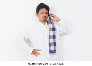 Shock And Confused Asian Muslim Man Using Mobile Phone Isolated On White Background