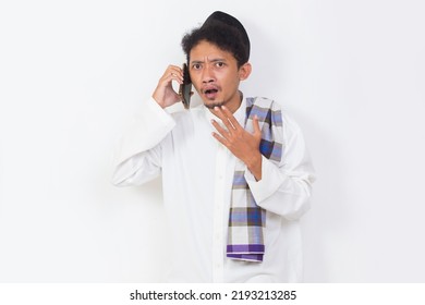 Shock And Confused Asian Muslim Man Using Mobile Phone Isolated On White Background