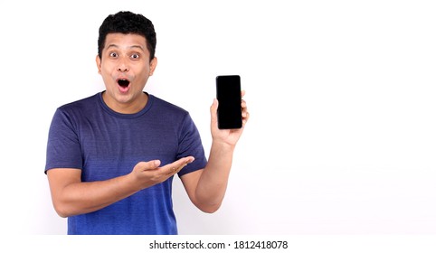 Shock And Surprise Face Of Asian Man Presenting Smart Phone On White Background In Studio With Copy Space.