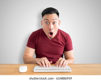 Shock And Wow Face Of Asian Man Sit On His Desk Working In The Office.