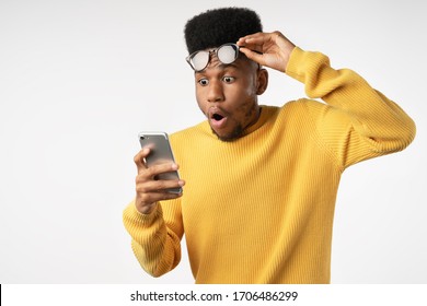 Shocked African Man While Watching In Smartphone On Isolated White Background