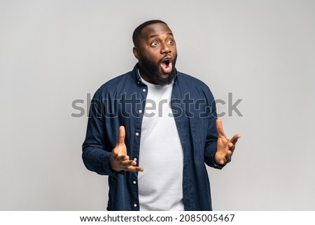 Shocked African-American guy staring away with awe expression, amazed black guy watching with disbelieve isolated on gray background Foto stock © 