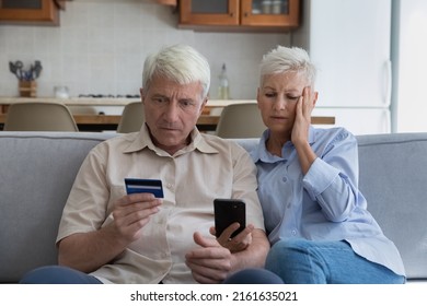 Shocked aged couple become victims of online fraud using credit card phone to pay for goods order service online on suspicious website. Frustrated older spouses overspending money at internet shopping - Shutterstock ID 2161635021