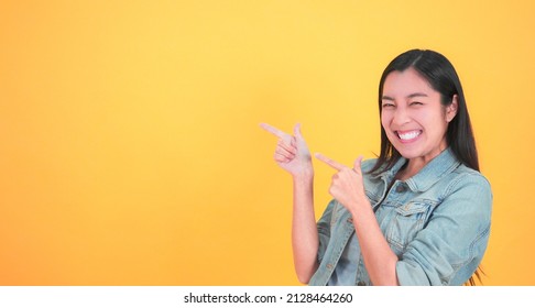 Shocked, amazed young beautiful asian woman 20s standing looking at camera with excited smile isolated on yellow background studio portrait. Facial, surprised and happy adorable rejoices success.