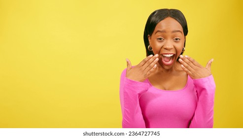 Shocked and amazed young woman puts hands to mouth, yellow studio - Shutterstock ID 2364727745