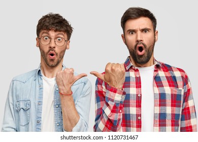 Shocked bearded male brothers indicate at each other with thumbs, lay blame, have stupefied expressions, dressed casually, isolated over white background. Men`s friendship and emotions concept - Shutterstock ID 1120731467