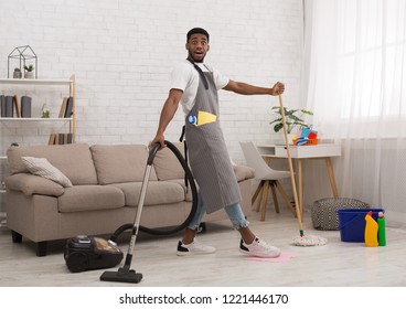 Shocked Black Guy Cleaning House With Mop And Vacuum Cleaner Simultaneously, Deadline And Lack Of Time Concept