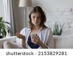 Shocked concerned cellphone user girl staring at screen, looking at smartphone screen, finding problems with online app, poor connection, Internet service, getting surprising bad news