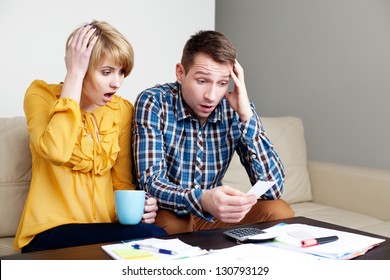 Shocked Couple Paying Bills At Home