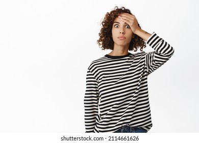 Shocked Curly Girl Slap Forehead, Looking Speechless And Startled, Worried, Forget Or Remember Smth, Embarassed Standing Against White Background