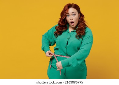 Shocked Dissatisfied Sad Young Ginger Chubby Overweight Woman 20s Years Old Wears Green Shirt Hold In Hand Use Sewing Meter Measures Her Waist Size Isolated On Plain Yellow Background Studio Portrait