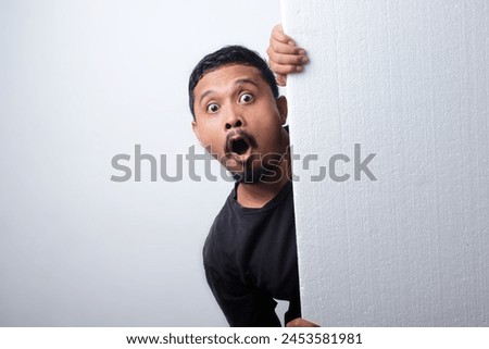 shocked expression of asian man while holding banner 