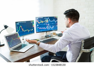 Shocked freelance stock broker gesturing while looking at graphs on computer screen - Shutterstock ID 1523848130