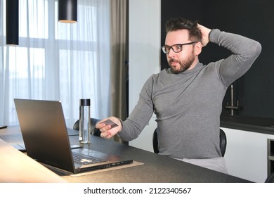 Shocked Horrified Surprised Confused Young Man, Stressed Worried Guy Having Problem With Paying, Buying Online, Payments With Credit Blocked Bank Card, Looking At Screen Of Laptop. Internet Fraud