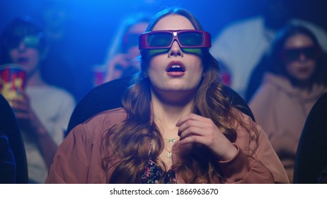 Shocked lady feeling scared at cinema. Closeup frightened girl sitting in movie theatre. Portrait of beautiful woman in 3d glasses watching horror movie indoors. - Powered by Shutterstock