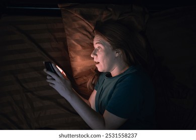 Shocked lady staring at smartphone with open mouth. Middle-aged woman reading surprising message on phone, amazing news at night - Powered by Shutterstock