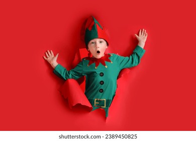 Shocked little elf visible through torn red paper