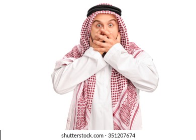 Shocked male Arab covering his mouth with his hands and looking at the camera isolated on white background