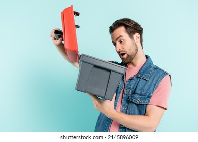 Shocked Man Looking At Open Toolbox Isolated On Blue