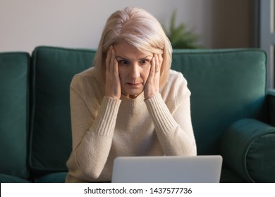Shocked middle aged mature woman feeling stressed reading unbelievable online news, surprised senior old lady looking at laptop amazed by unexpected stuck computer problem sit on sofa at home - Shutterstock ID 1437577736