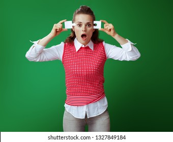 Shocked Modern Learner Woman In Grey Jeans And Pink Sleeveless Shirt Trying To Assemble 2 Pieces Of The Puzzle Against Green Background. Analytical Thinking, Real-world Issues And Problems Solving