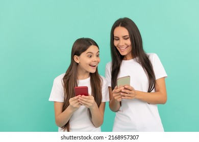 Shocked Mother And Daughter Chatting On Smartphone On Blue Background