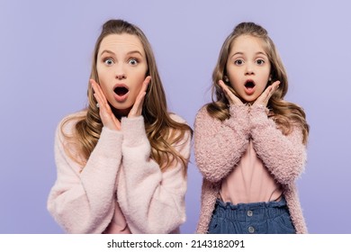 Shocked Mother And Daughter Looking At Camera Isolated On Purple