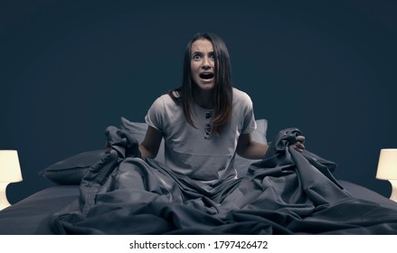 Shocked Scared Woman Waking Up From A Nightmare In Her Bed At Night