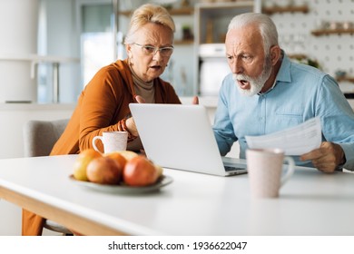 Shocked Senior Couple Reading Their Home Finances On Laptop