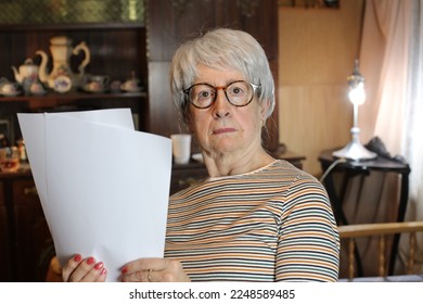 Shocked senior woman reading some documents - Powered by Shutterstock