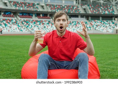 Shocked Soccer Fan In Red Tshirt With Glass Of Beer Watching Football Game In Stadium Fan Zone.