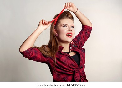 Shocked And Surprised Attractive Girl Smiling Looking To The Side Presenting Your Product . Curly Hair Woman Amazed .Beautiful Girl With Red Candy. Expressive Facial Expressions ,red Lips.Pin Up