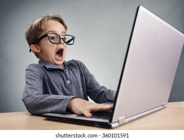 Un garçon choqué et surpris sur Internet avec un concept d'ordinateur portable pour étonner, étonner, faire une erreur, stupéfait et sans voix ou voir quelque chose qu'il ne devrait pas voir