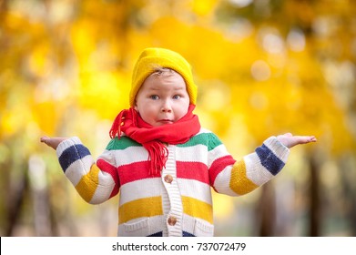 Shocked and surprised child. Cheerful little boy opens his mouth in surprise. child walking in autumn park with red scarf on neck.