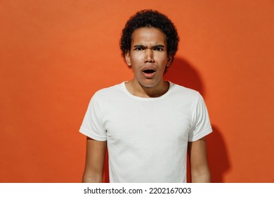 Shocked Surprised Impressed Frightened Upset Young Black Curly Man 20s Years Old Wears White T-shirt Looking Camera Keeping Mouth Wide Open Isolated On Plain Pastel Orange Background Studio Portrait