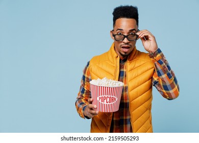 Shocked Surprised Sad Young Black Man 20s Years Old Wears Yellow Waistcoat Shirt Watch Movie Film Hold Bucket Of Popcorn Take Off Glasses Isolated On Plain Pastel Light Blue Background Studio Portrait