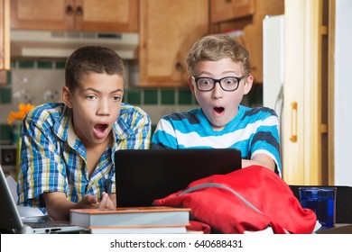 Shocked Teen Males Looking At Laptop Computer At Home