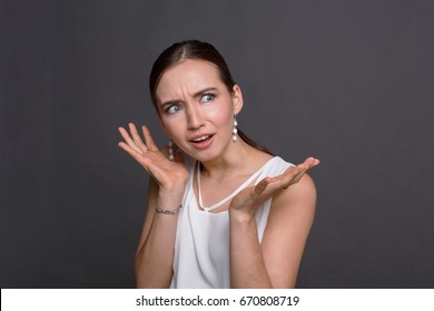 Shocked woman with arms up in air in full disbelief. Surprised girl portrait, dark background. Omg, wtf, human emotions concept