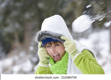 Shocked Woman Having Snowball Fight In Woods