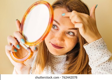 Shocked Woman Looking At Pimple On Forehead In Mirror.