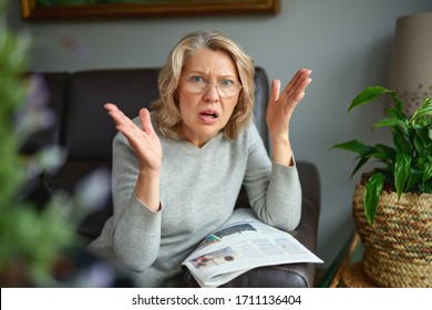 Shocked woman reading newspaper. Bad news.