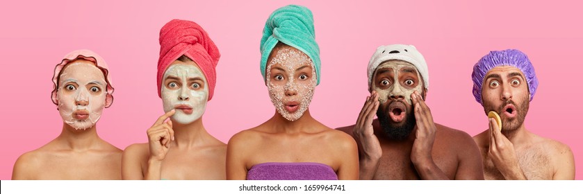 Shocked women and men of different races wear applied face masks, have beauty treatments after taking shower, listen advice of cosmetologist, stand next to each other, express wonder and say omg