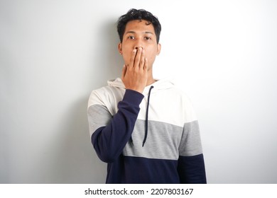 Shocked worried, embarrassed young man said something he shouldnt have, shut his mouth with hands and look guilty or anxious at camera, feel sorry for being rude, white background