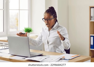 Shocked worried young woman looking at laptop computer screen. Stressed Afro American girl in panic frustrated with computer problem, mistake ,virus, lose data files or negative social media message - Shutterstock ID 2298684277