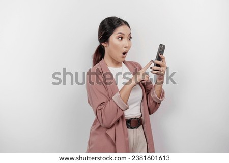 Shocked young Asian woman employee wearing cardigan is  holding her phone, isolated by white background