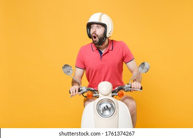 Shocked Young Bearded Man Guy In Casual Summer Clothes Helmet Driving Moped Isolated On Yellow Background Studio Portrait. Driving Motorbike Transportation Concept. Mock Up Copy Space. Looking Aside