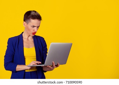 Shocked Young Business Woman Using Laptop Looking At Computer Screen Blown Away In Stupor On  Office Yellow Background. Human Face Expression, Emotion, Feeling, Perception, Body Language, Reaction