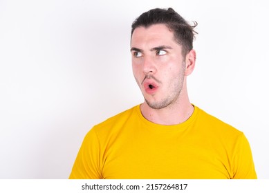 Shocked Young caucasian man wearing yellow t-shirt over white background look empty space with open mouth screaming: Oh My God! I can't believe this. - Shutterstock ID 2157264817