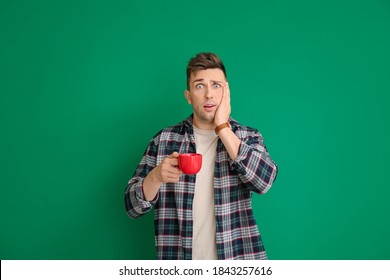 Shocked Young Man With Coffee On Color Background